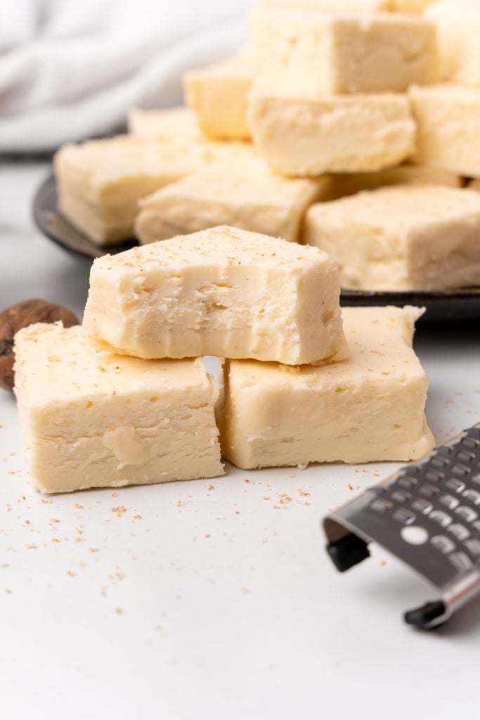 a stack of 30 minute eggnog flavored fudge with a bite taken out of the top piece
