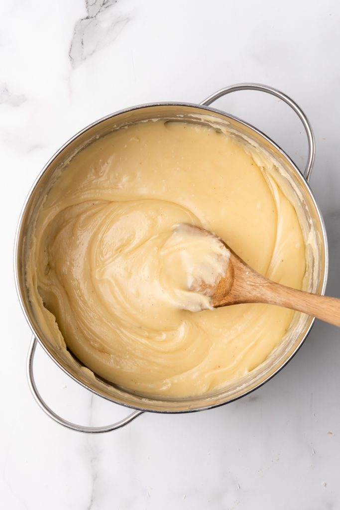 white chocolate fudge batter in a skillet with a wooden spoon