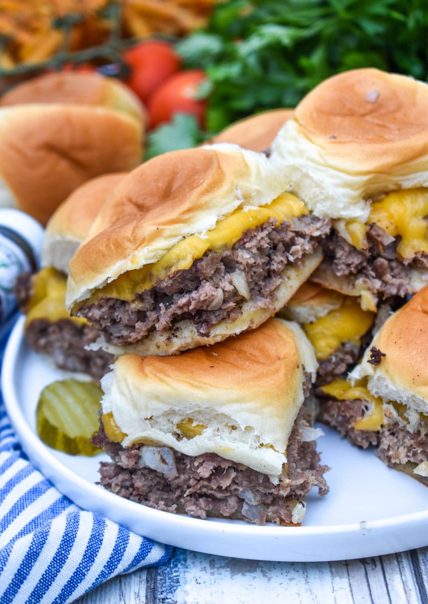 easy cheeseburger sliders stacked on a white plate