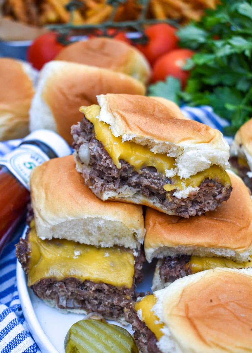 easy cheeseburger sliders stacked on a white plate