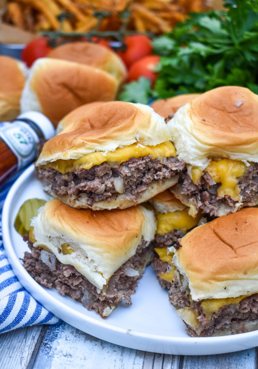 easy cheeseburger sliders stacked on a white plate
