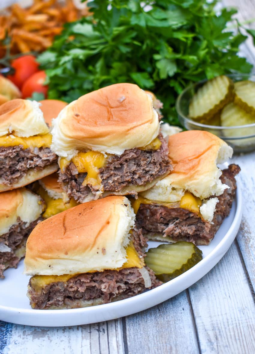easy cheeseburger sliders stacked on a white plate