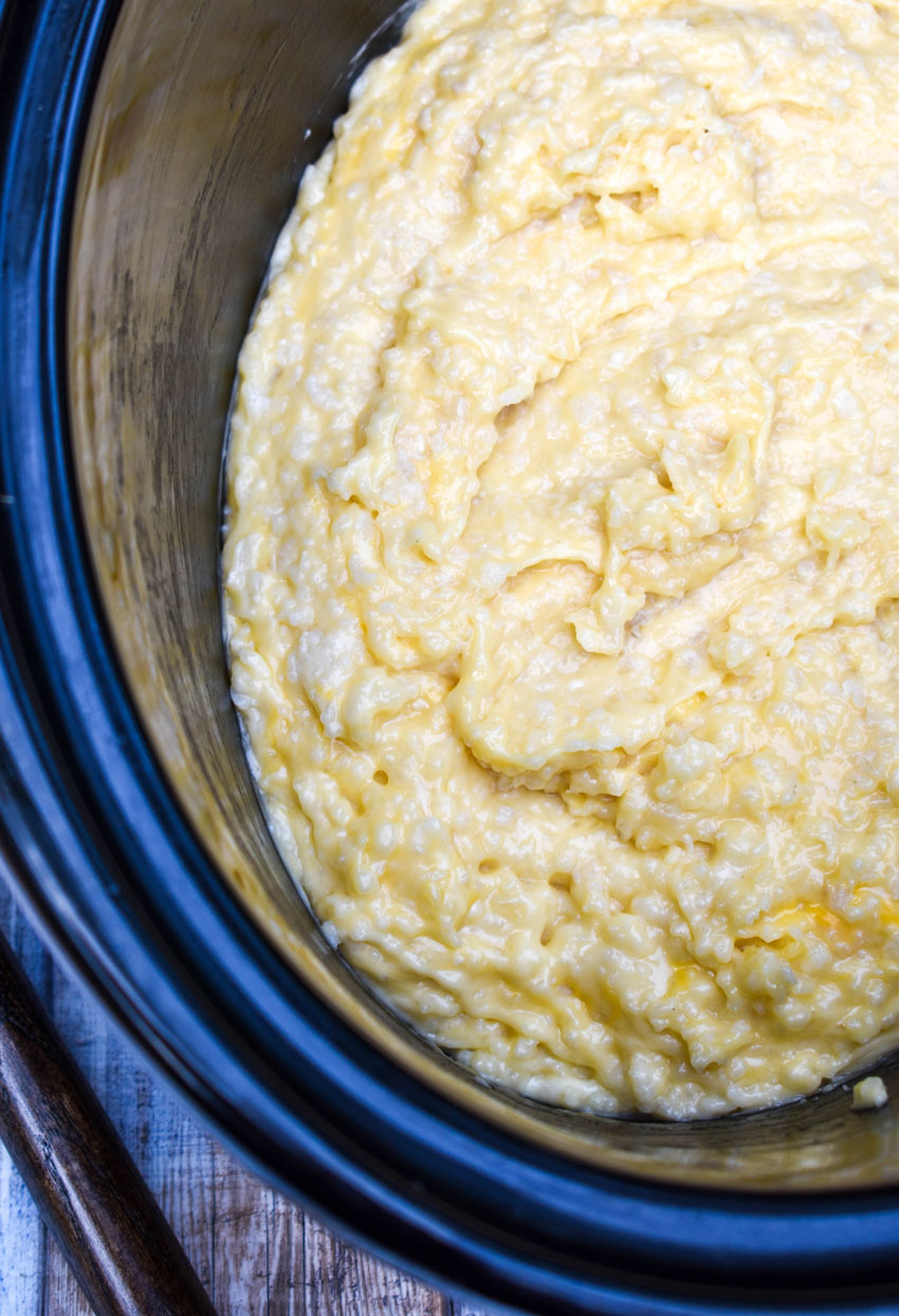 cheesy crockpot risotto in the black bowl of a slow cooker