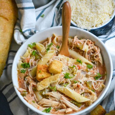 crockpot chicken parmesan soup served in a soup bowl with a wooden spoon