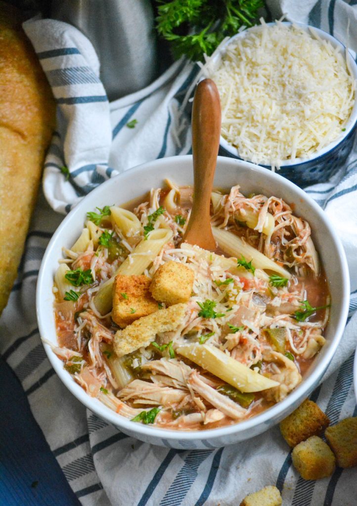 crockpot chicken parmesan soup served in a soup bowl with a wooden spoon