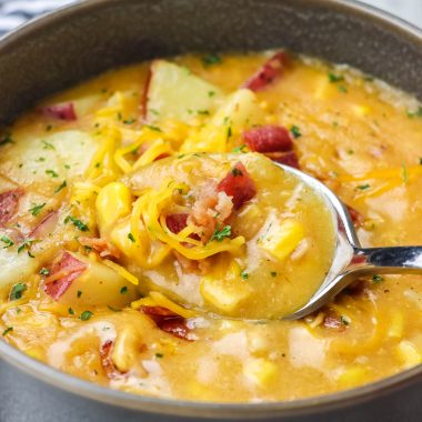 a silver spoon shown scooping up a spoonful of creamy, corn filled instant pot smoky bacon and cheddar chowder