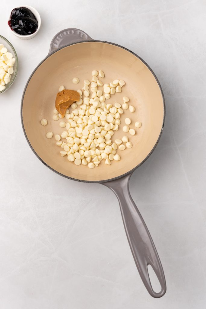 white chocolate chips and peanut butter in a gray skillet