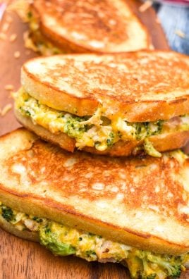 chicken and broccoli grilled cheese sandwiches stacked on a wooden cutting board