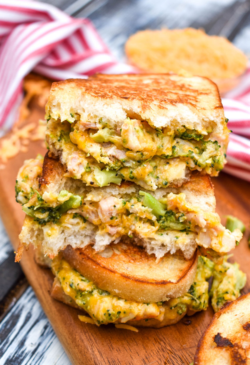 grilled cheese with chicken and broccoli cut in half and serve on a wooden serving platter