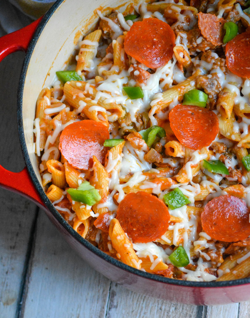 ONE POT PIZZA PASTA IN A RED POT ON A WOODEN TABLE