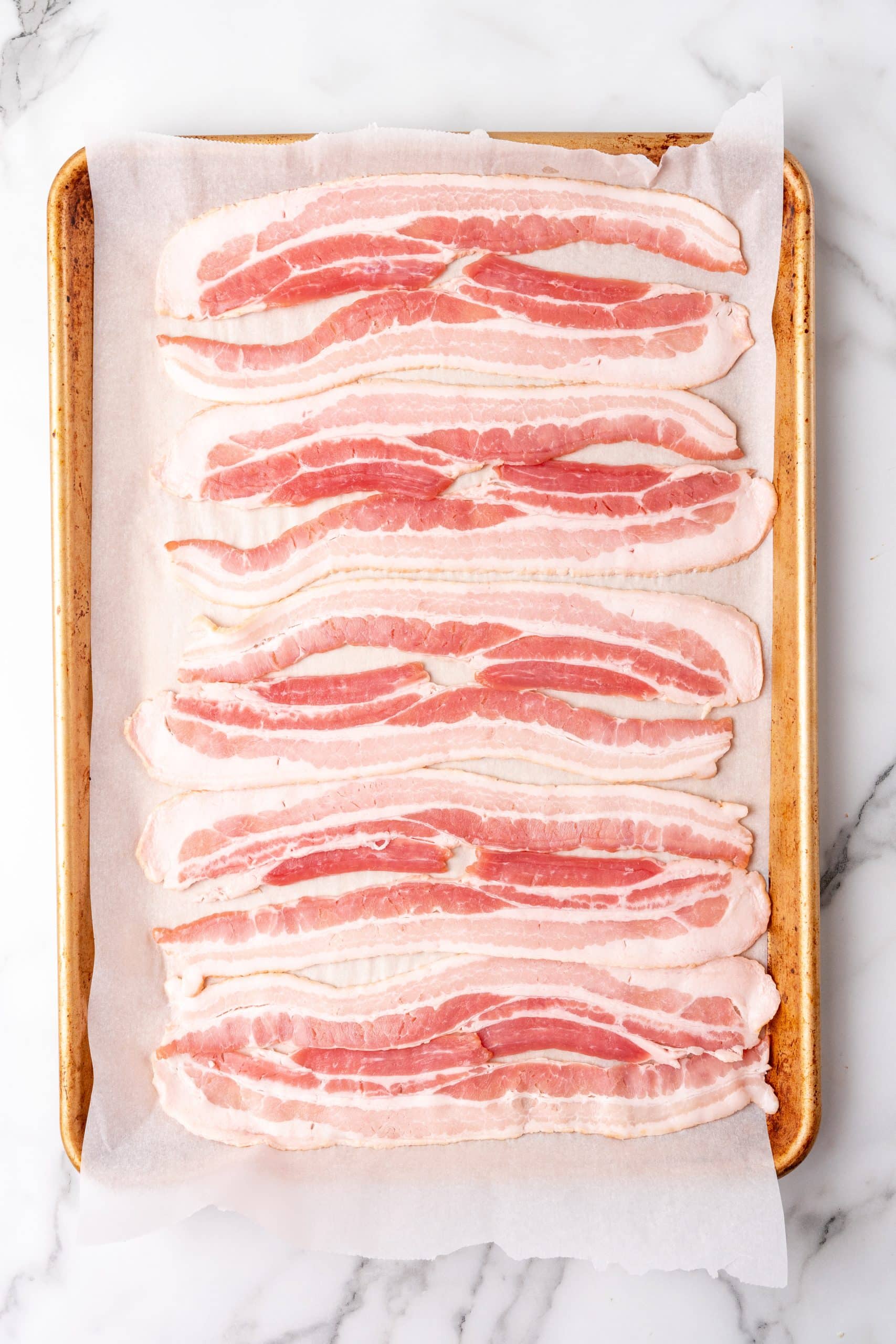 slices of bacon on a parchment paper lined baking sheet
