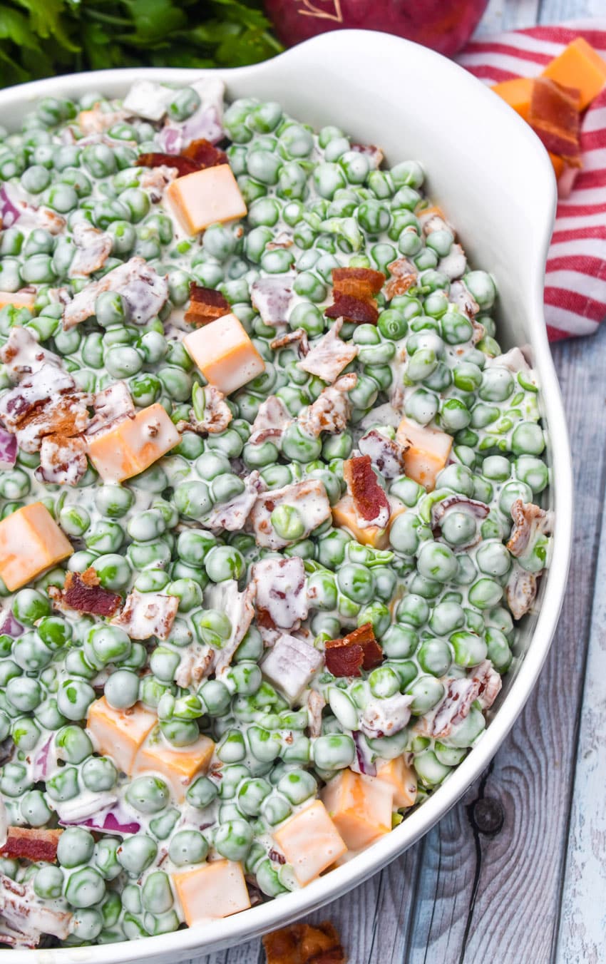 bacon and pea salad in a large white serving bowl