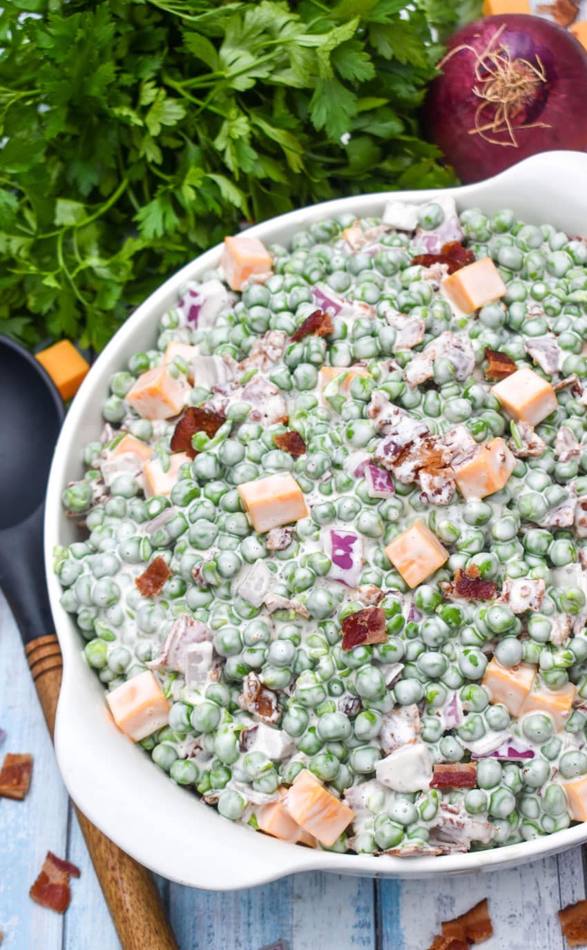 bacon and pea salad in a large white serving bowl