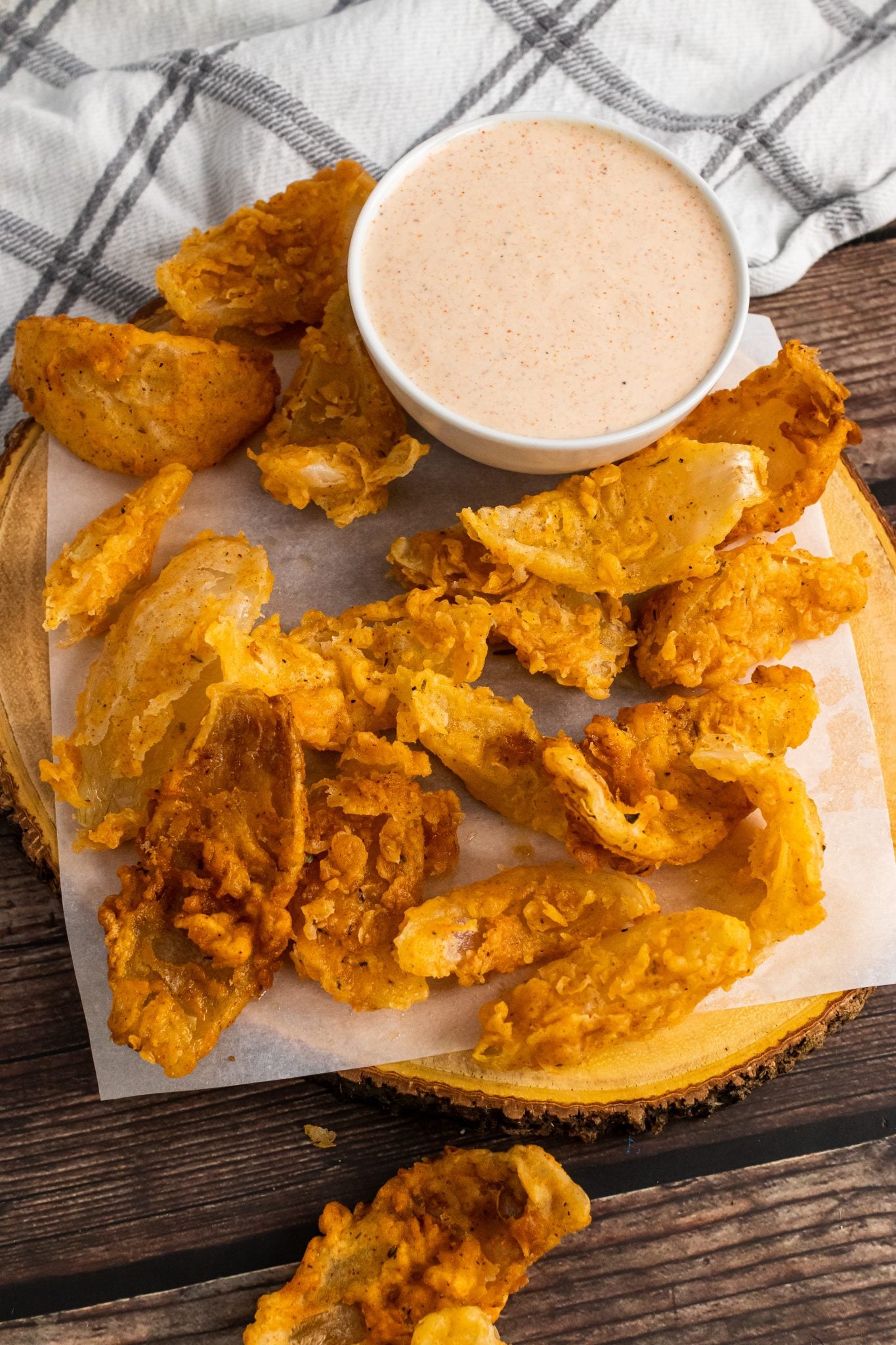 Air fryer blooming onion bites golden crispy individual petals for party sharing appetizer with spicy dipping sauce