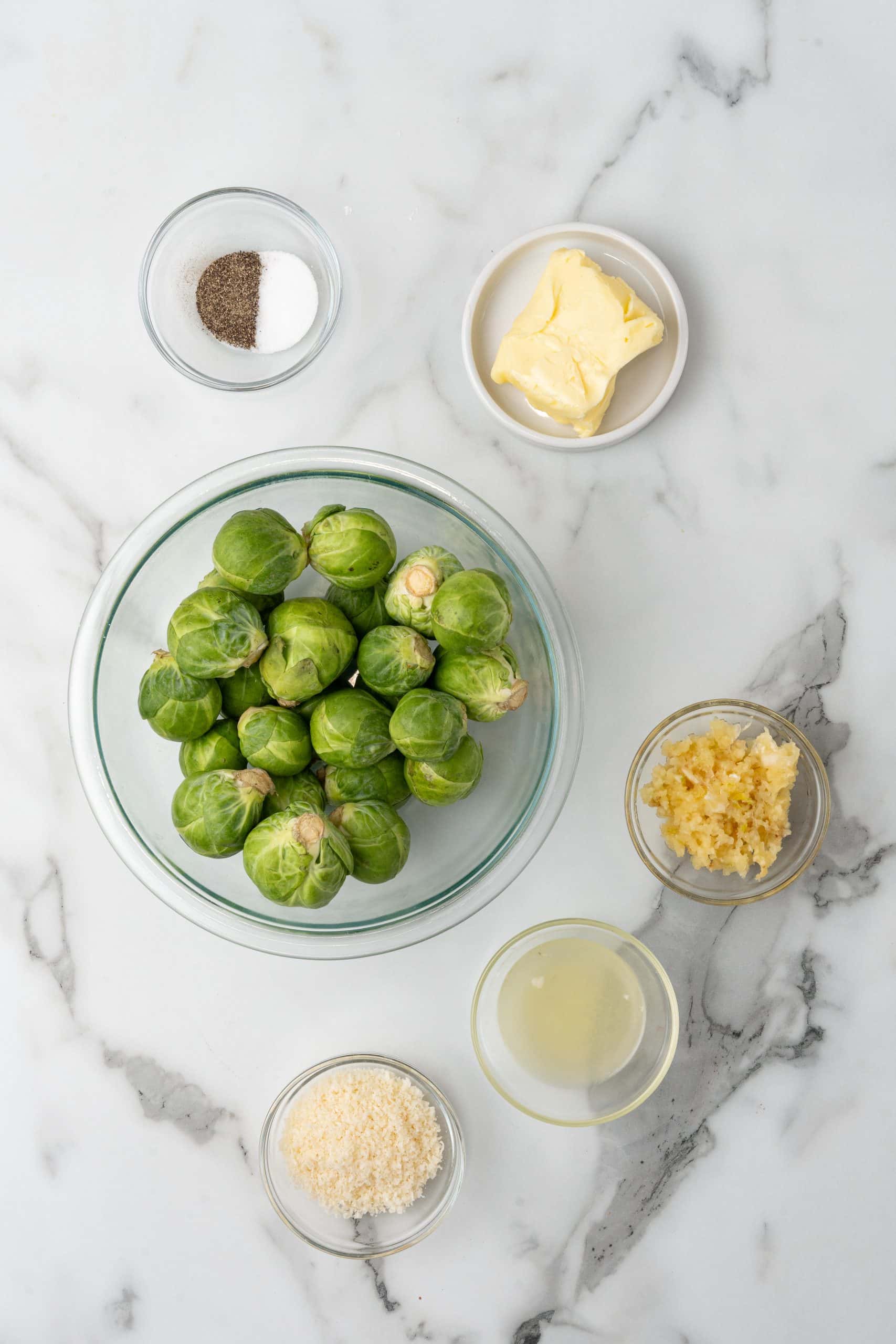 an overhead image showing the measured ingredients needed to make a batch of sauteed brussels sprouts with lemon and garlic