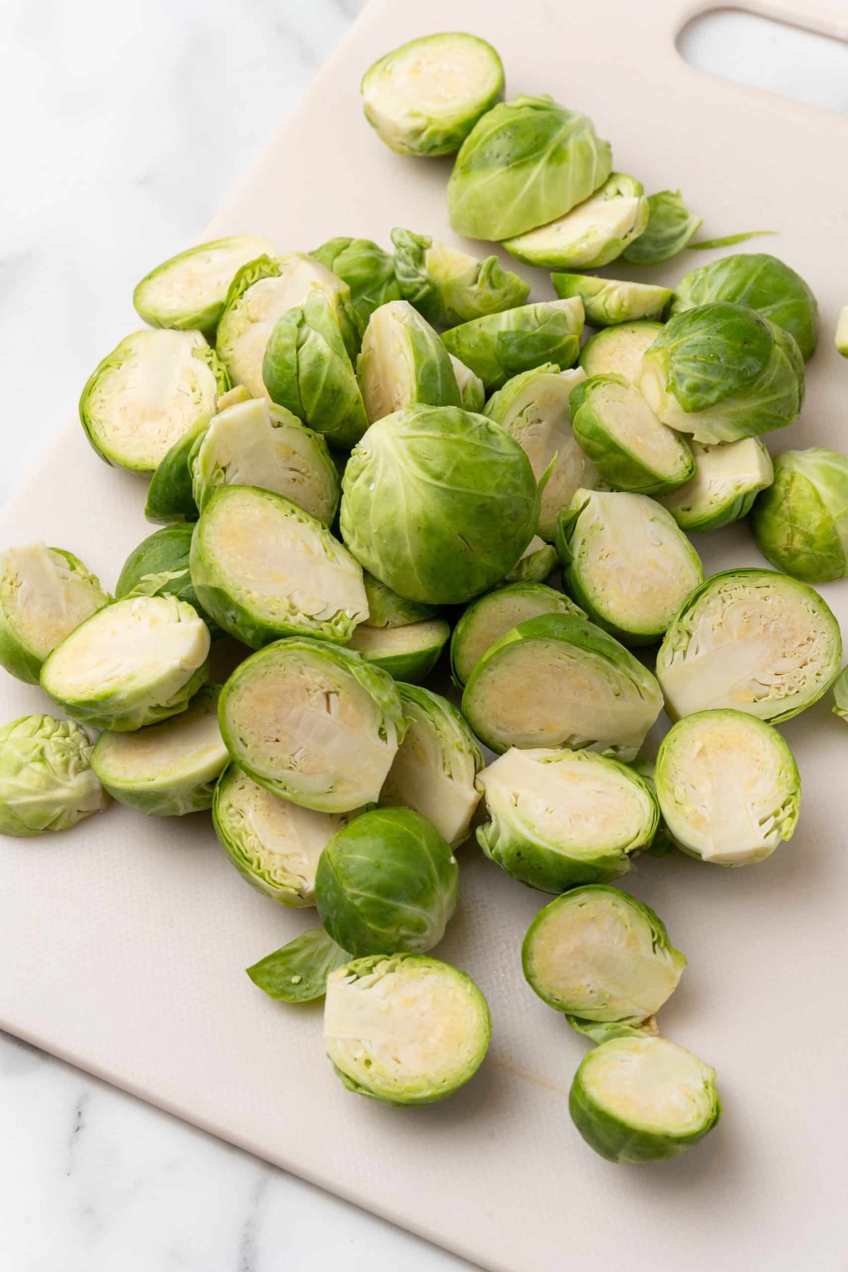 halved fresh brussels sprouts on a white cutting board