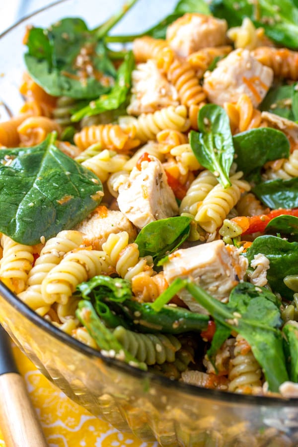 Asian Style Chicken Spinach Pasta Salad in a glass bowl