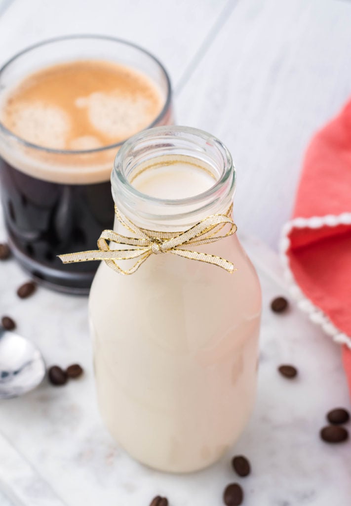 homemade french vanilla coffee creamer in a glass milk jug with a ribbon tied around it