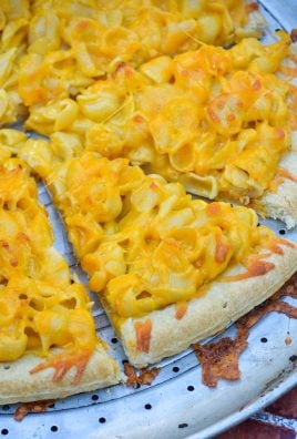 slices of baked mac and cheese pizza on a silver pizza pan