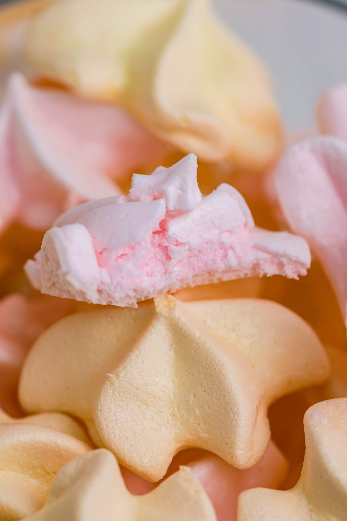 pink & yellow kool-aid meringue cookies in a small glass bowl