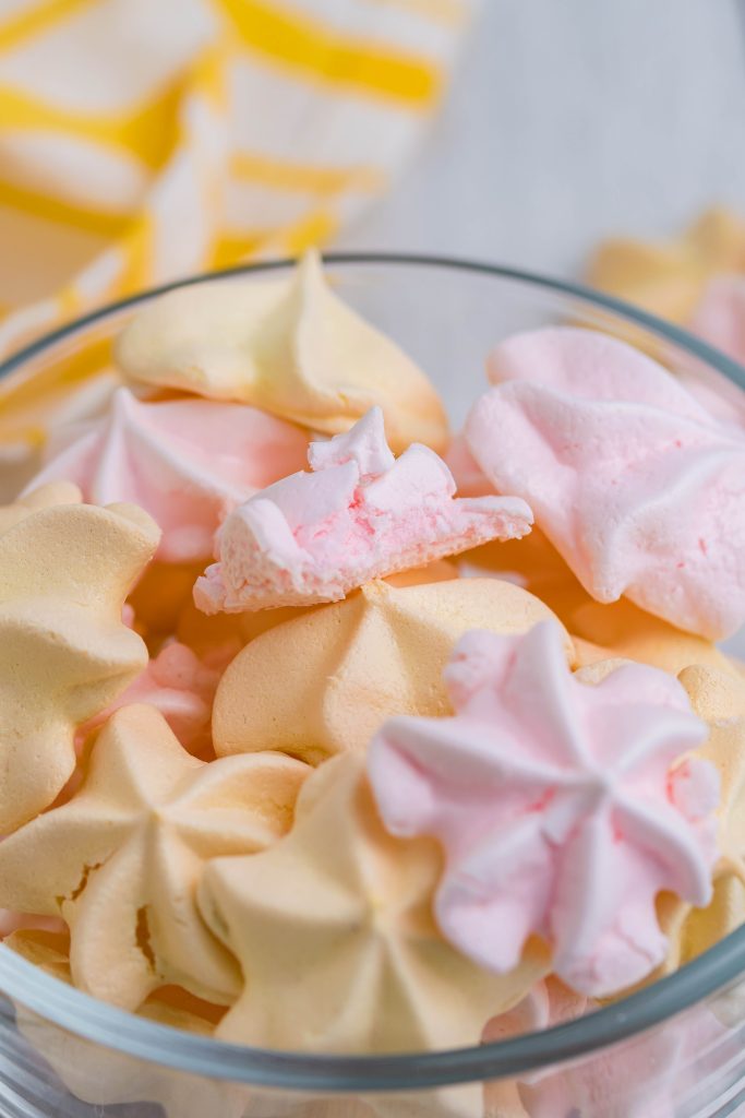 pink & yellow kool-aid meringue cookies in a small glass bowl