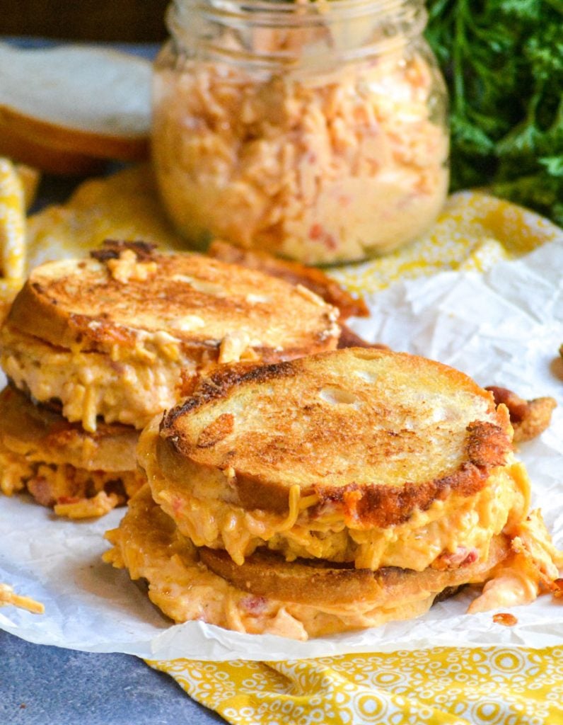 pimento cheese grilled cheese sandwiches shown on crinkled white parchment paper
