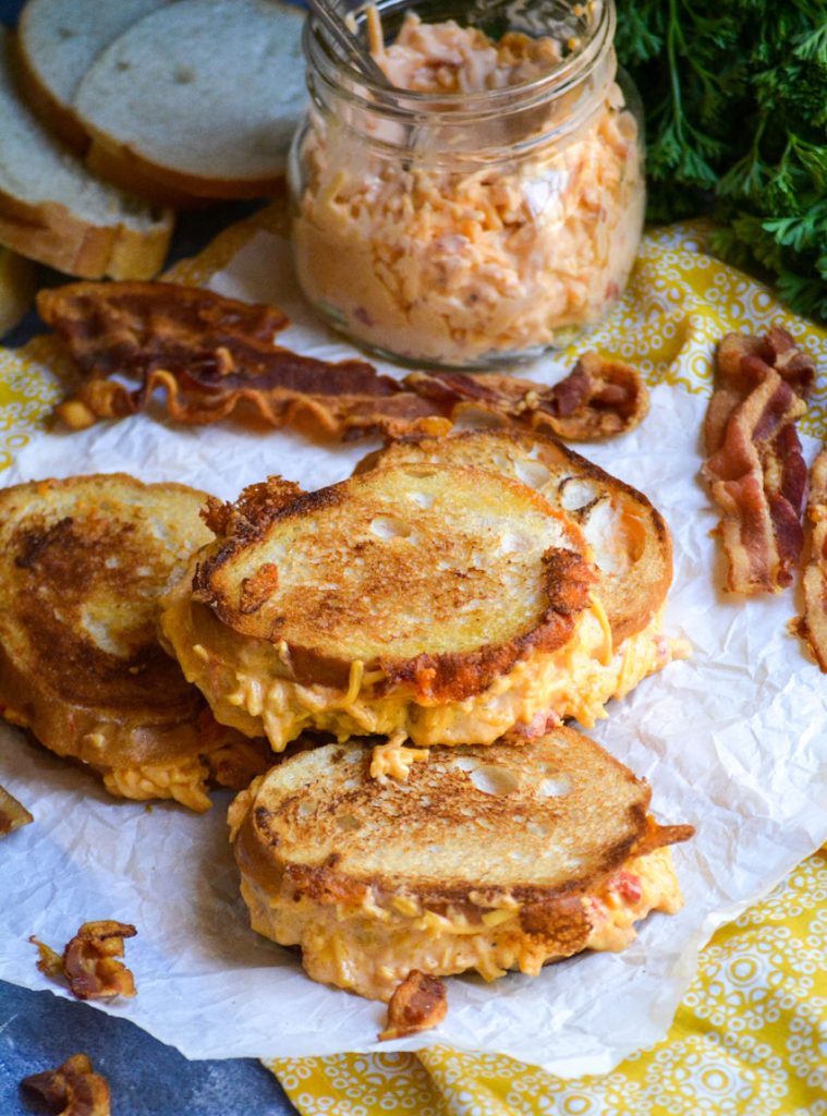 pimento cheese grilled cheese sandwiches shown on crinkled white parchment paper