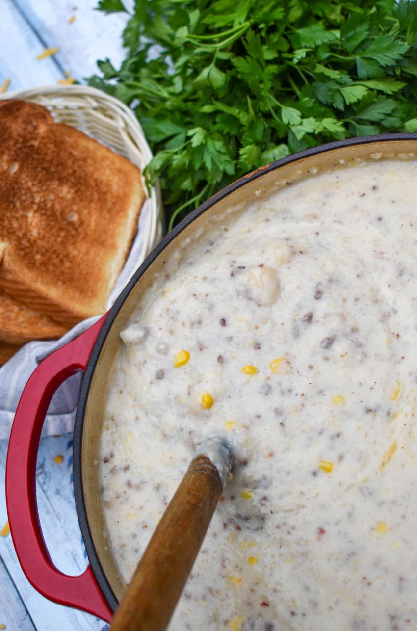 sausage and grits chowder in a large red dutch oven