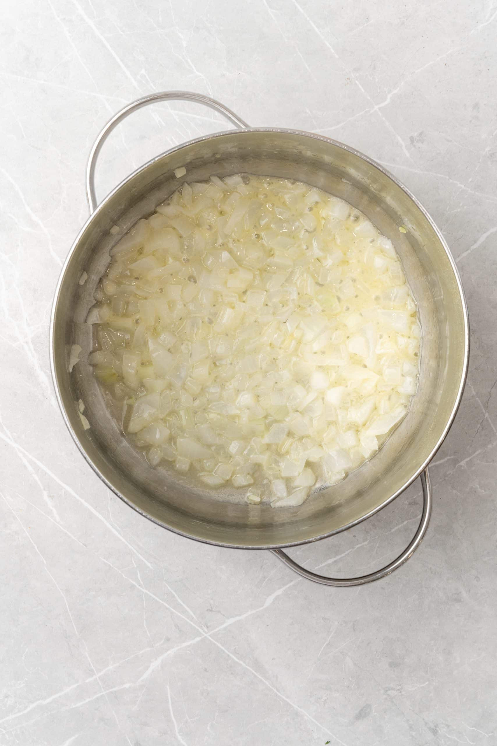 sauteed onions in butter in a silver pot