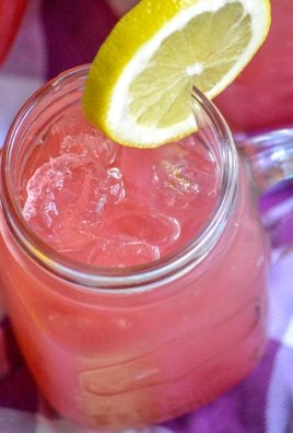 fresh blackberry lemonade in a glass topped with a fresh slice of lemon