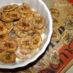 banana chips in a white bowl on top of a silpat lined baking sheet