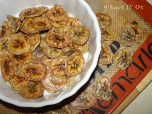 banana chips in a white bowl on top of a silpat lined baking sheet