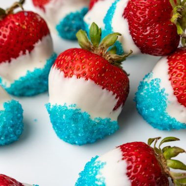 red white and blue chocolate covered strawberries arranged on a white plate