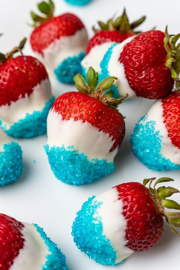 red white and blue chocolate covered strawberries arranged on a white plate