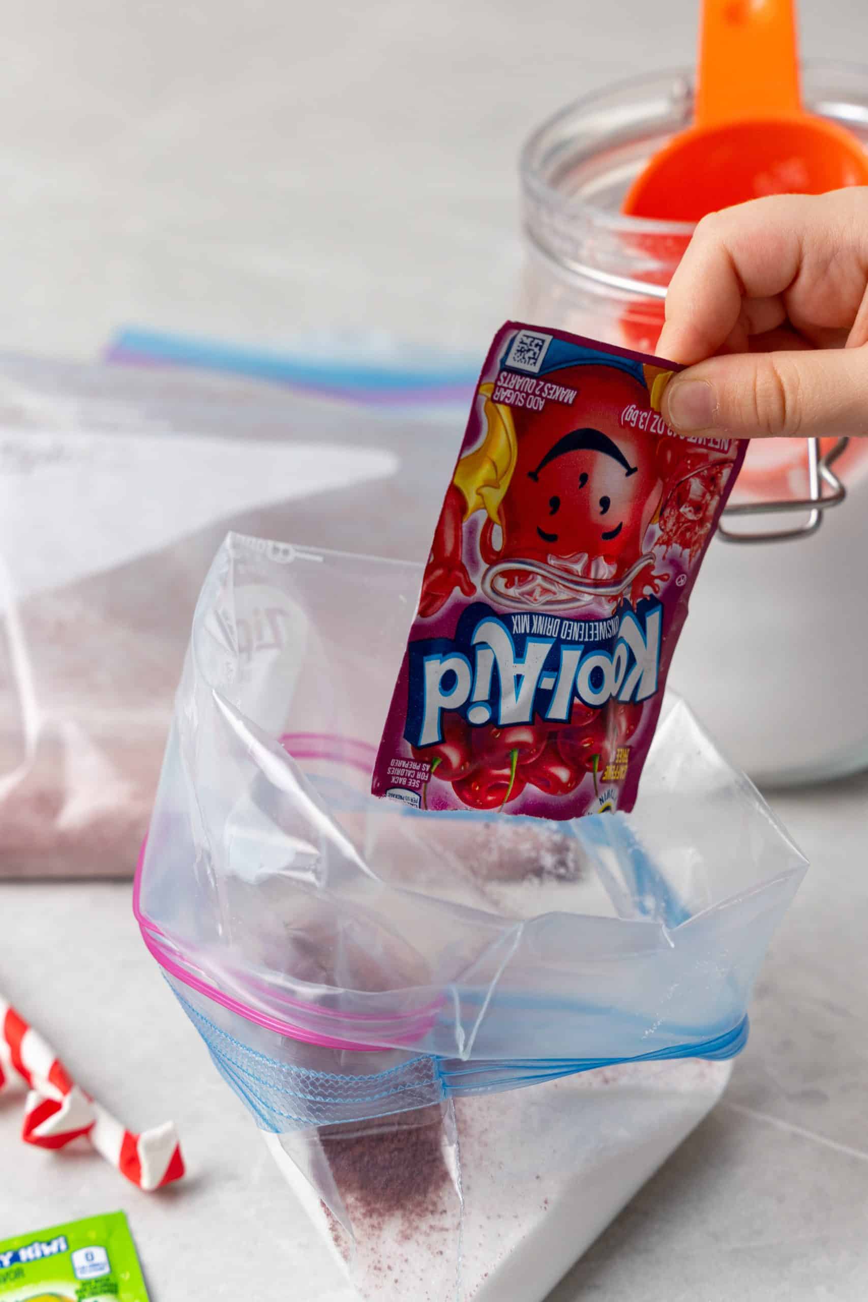 a packet of kool aid being poured into a bag of granulated sugar