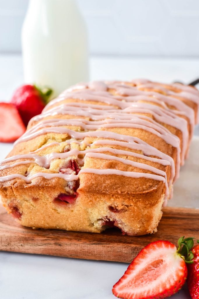 glazed strawberry bread served on a wooden cutting board