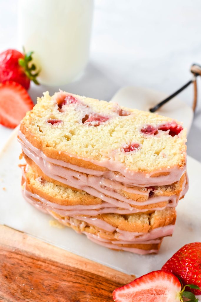 glazed strawberry bread shown sliced and stacked on a serving board