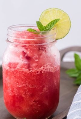 watermelon slushie in a glass jar with a slice of lime and mint leaves on the rim for garnish