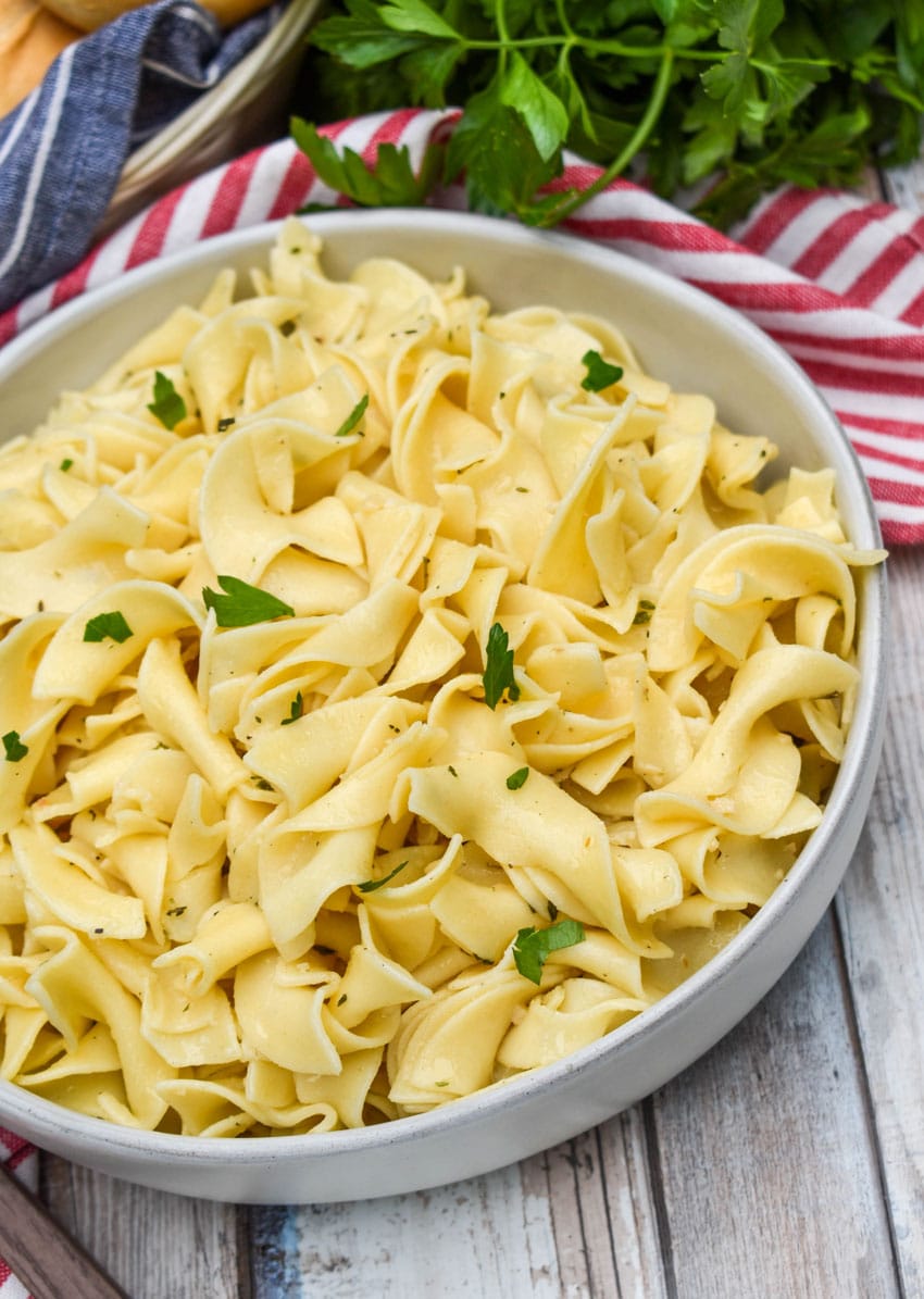 garlic herbed buttered noodles in a shallow gray bowl