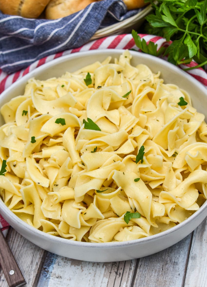 garlic herbed buttered noodles in a shallow gray bowl