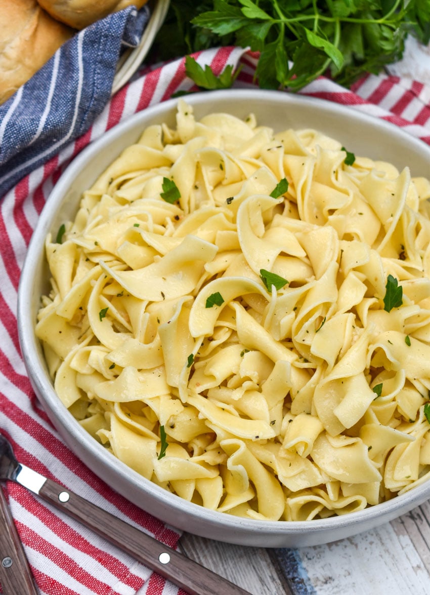 garlic herbed buttered noodles in a shallow gray bowl