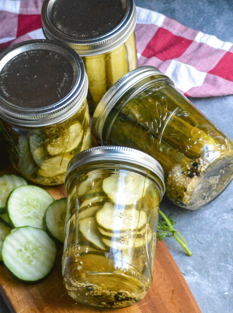mason jars filled with refrigerator pickles shown on a wooden cutting board