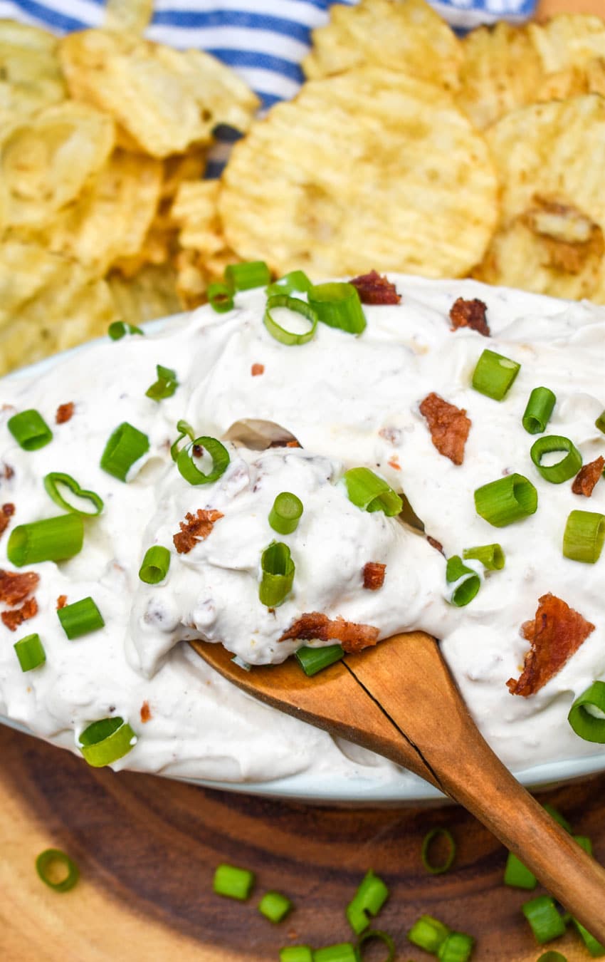 a wooden spoon in a bowl of creamy bacon horseradish dip