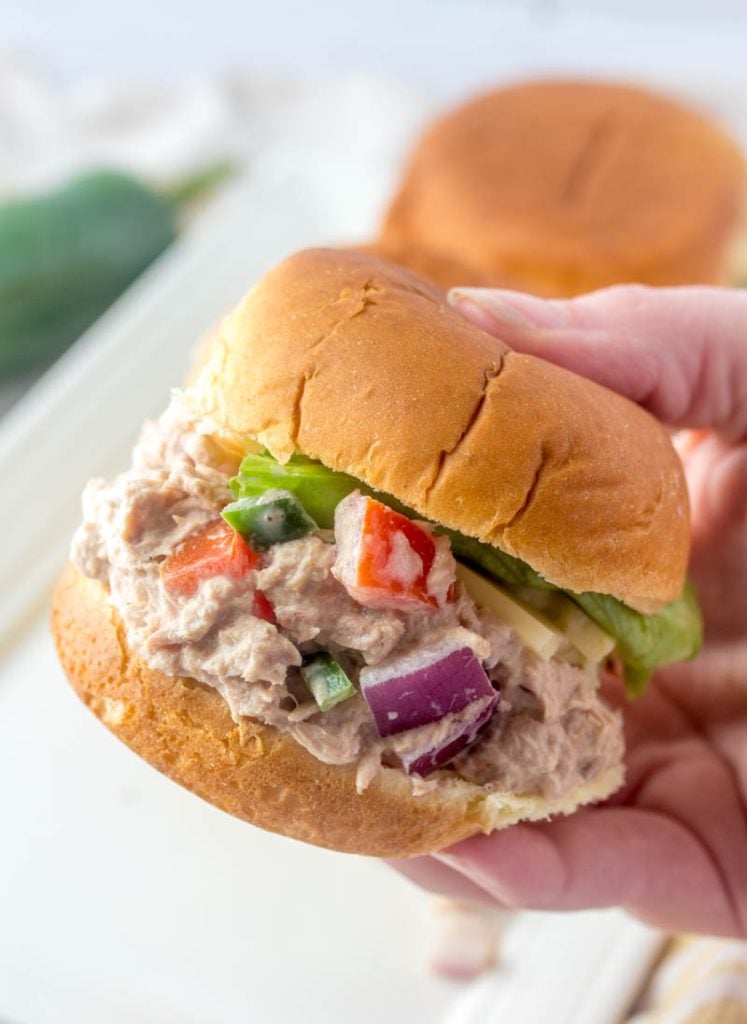 Fiesta Tuna Salad Sliders; a close up shot with one slider held up by a hand