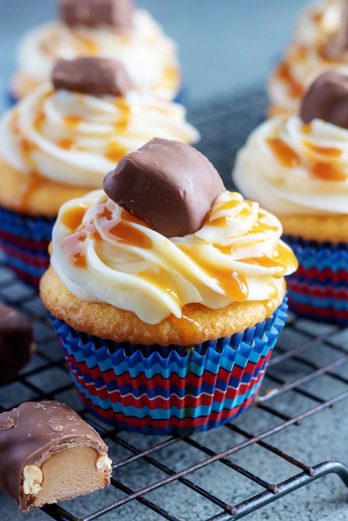 Baby Ruth Cupcakes shown on a black metal wire cooling rack