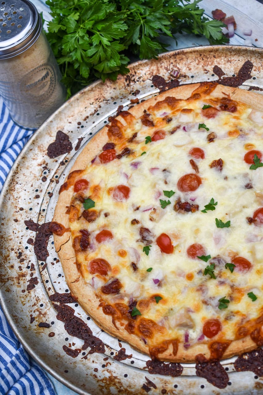 garlic chicken bacon ranch pizza on a metal pizza pan