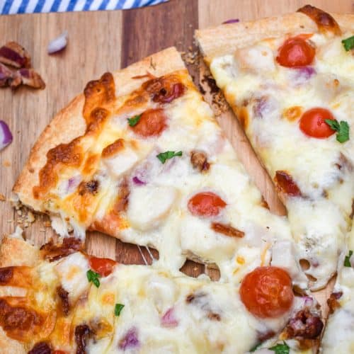 garlic chicken bacon ranch pizza on a wooden pizza peel