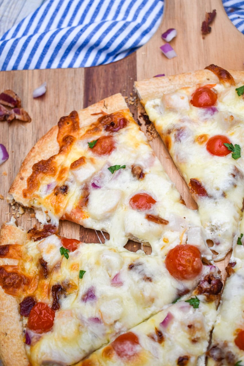 garlic chicken bacon ranch pizza on a wooden pizza peel