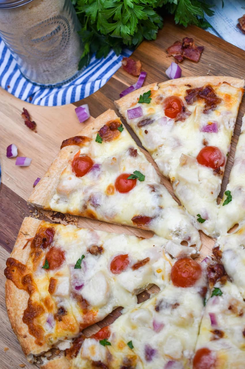 garlic chicken bacon ranch pizza on a wooden pizza peel