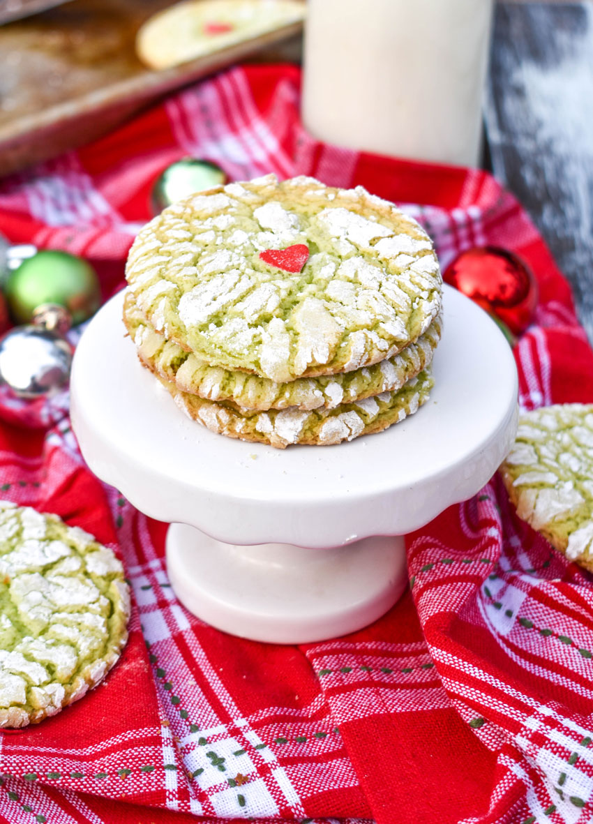 a stack of grinch cookies on a mini white pedestal